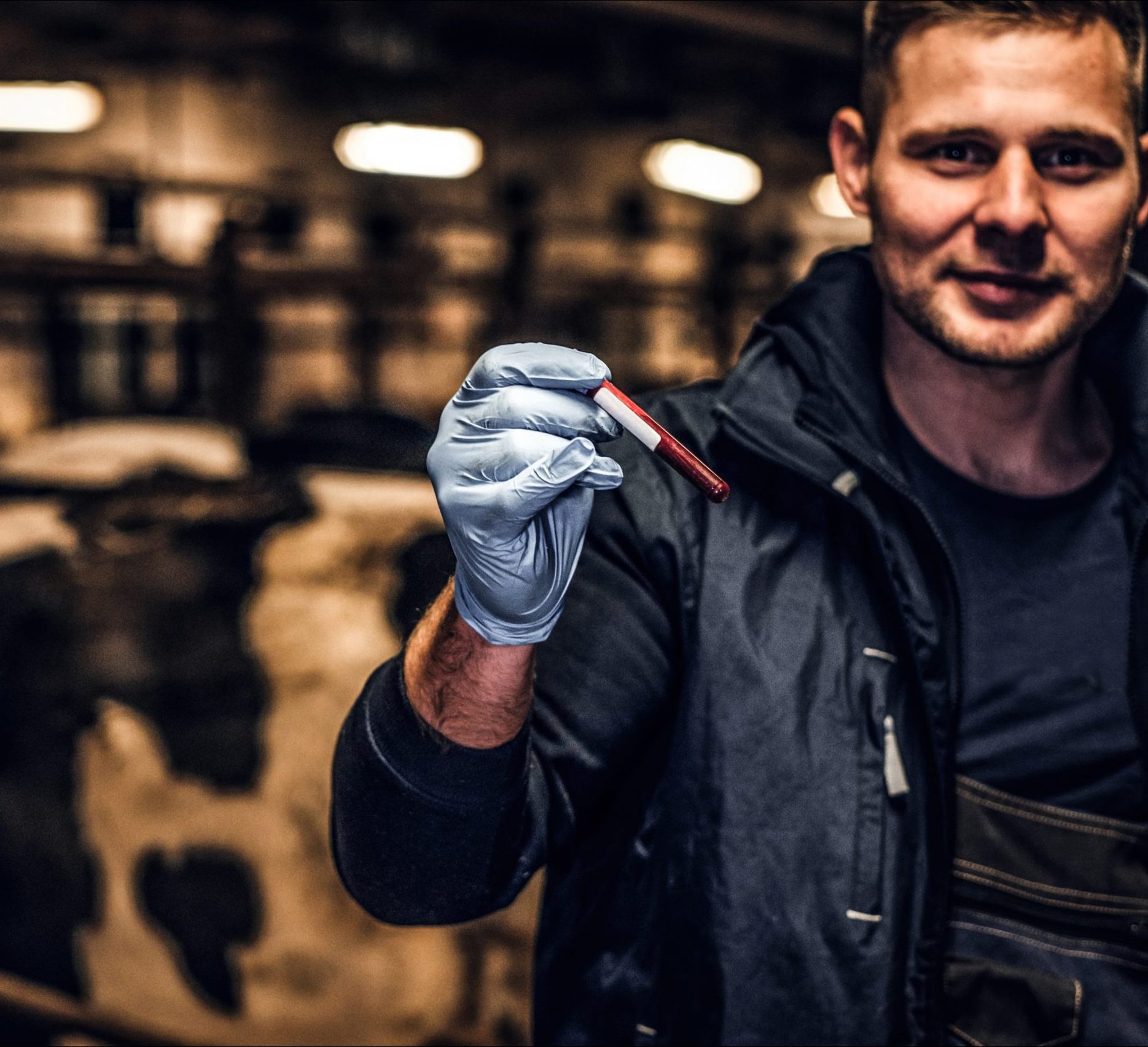 Vet holding a sample in a cattle shed - TB Hub